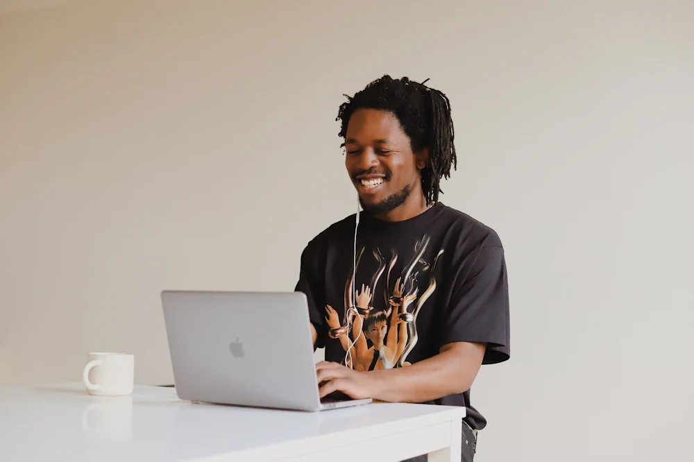 Man smiling while working on a laptop