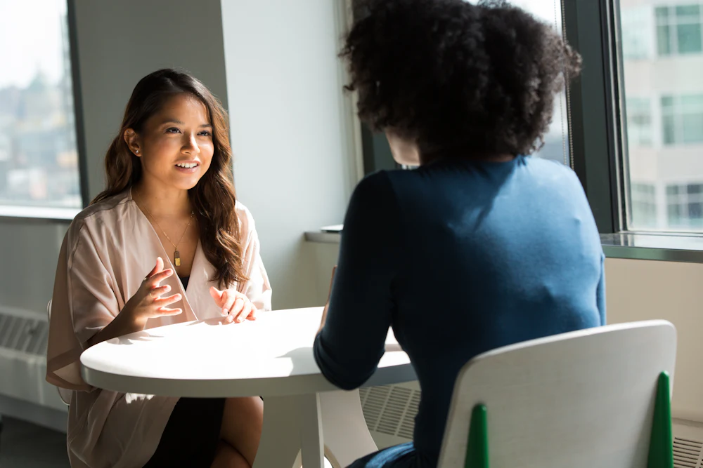 HR manager in conversation with an employee at a small table