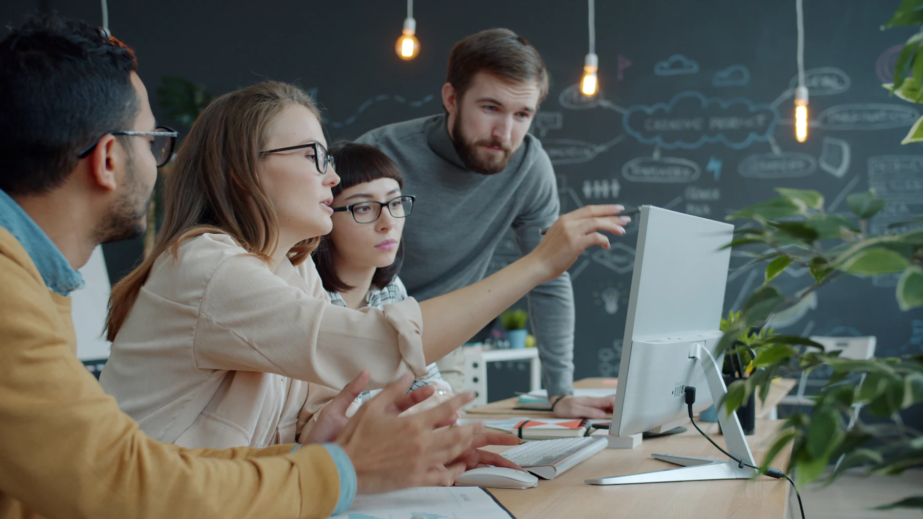 A team discussing data on a computer screen