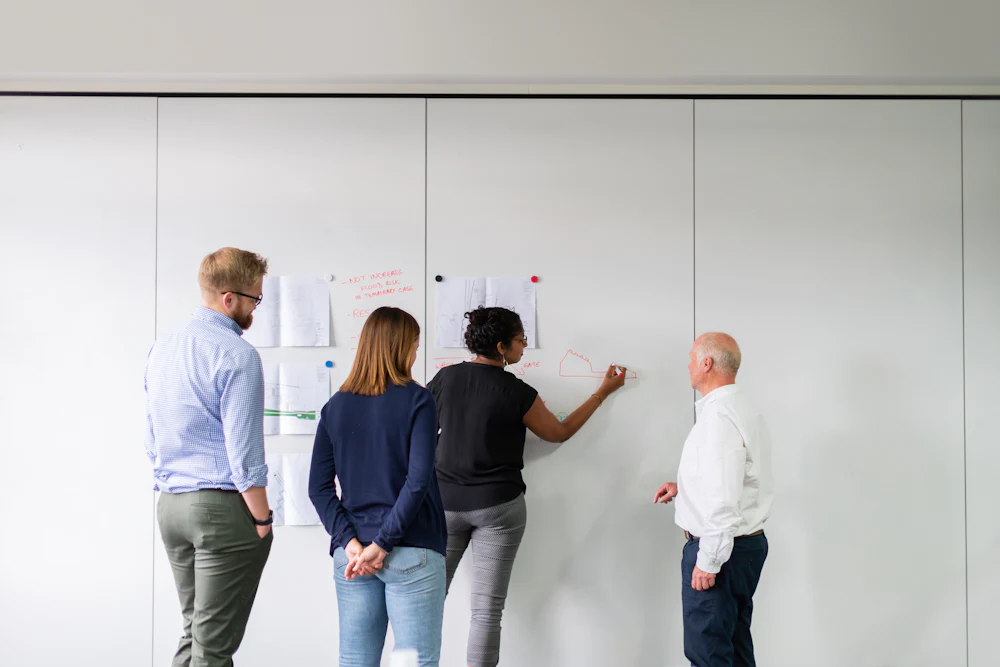 Colleagues of different ages planning at a whiteboard
